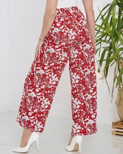 Spodnie Materiałowe^Royalfashion Damskie czerwone spodnie typu palazzo z białymi kwiatami czerwony