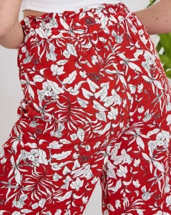 Spodnie Materiałowe^Royalfashion Damskie czerwone spodnie typu palazzo z białymi kwiatami czerwony