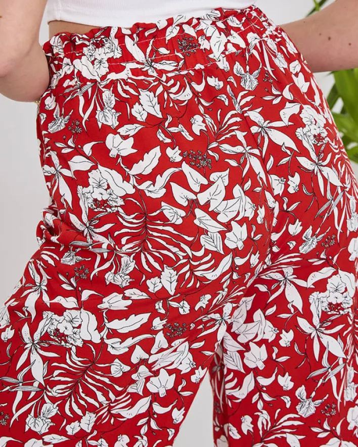 Spodnie Materiałowe^Royalfashion Damskie czerwone spodnie typu palazzo z białymi kwiatami czerwony