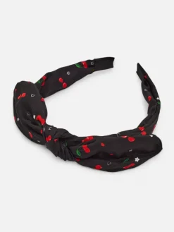 Akcesoria Do Włosów^Royalfashion Dziecięca opaska do włosów z kokardką z printem w wisienki czarny
